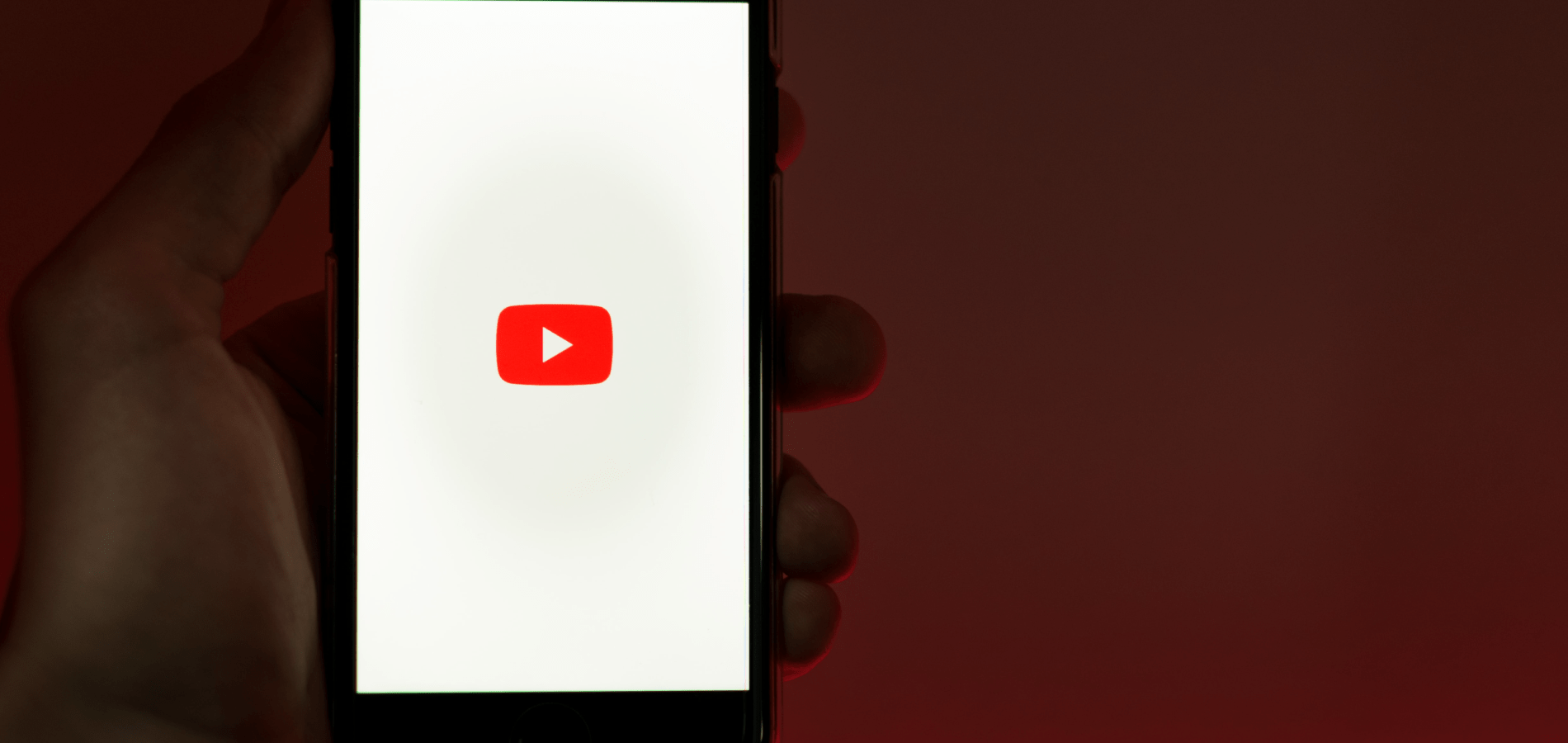 Person holding cell phone with the YouTube logo on it