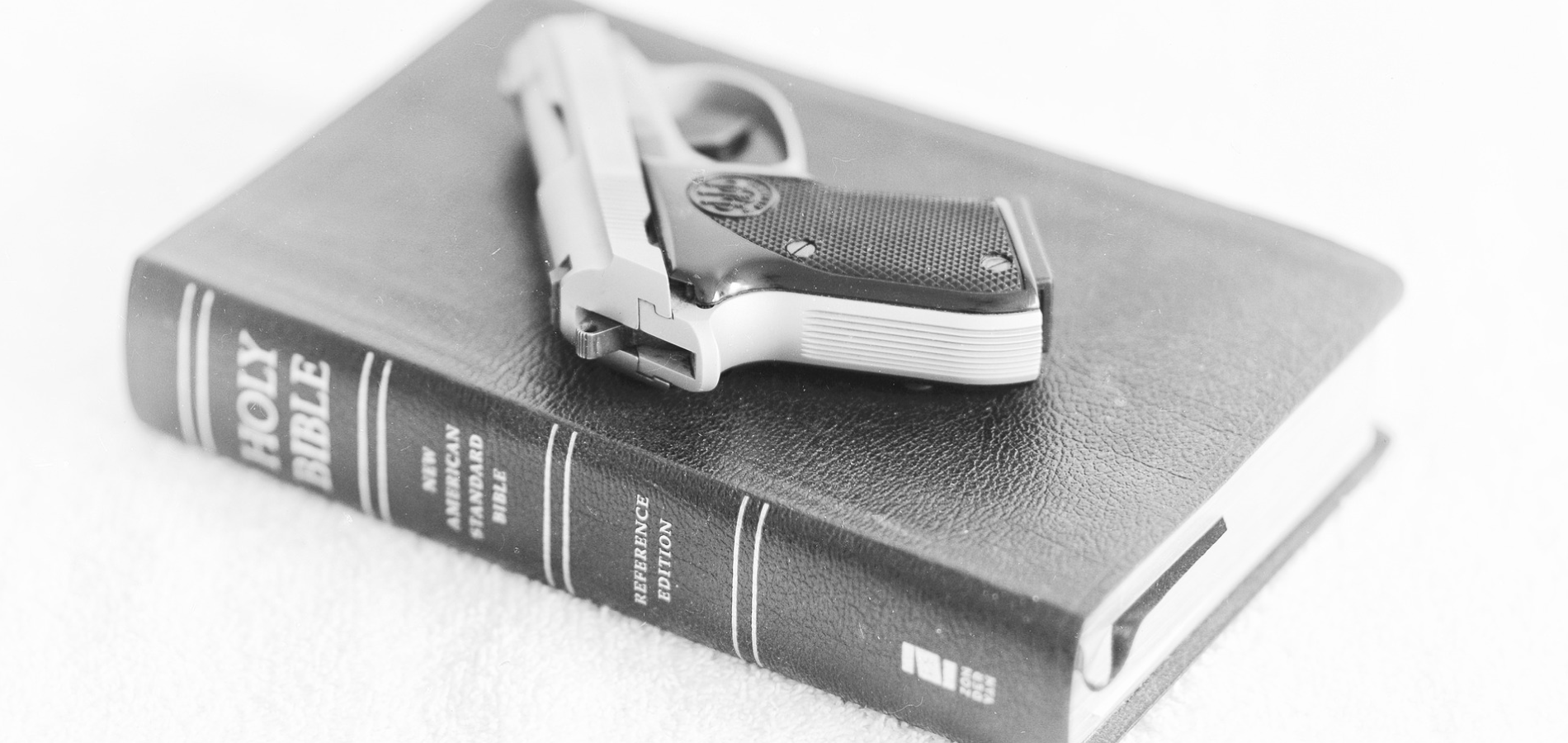 A gun sitting on top of a bible