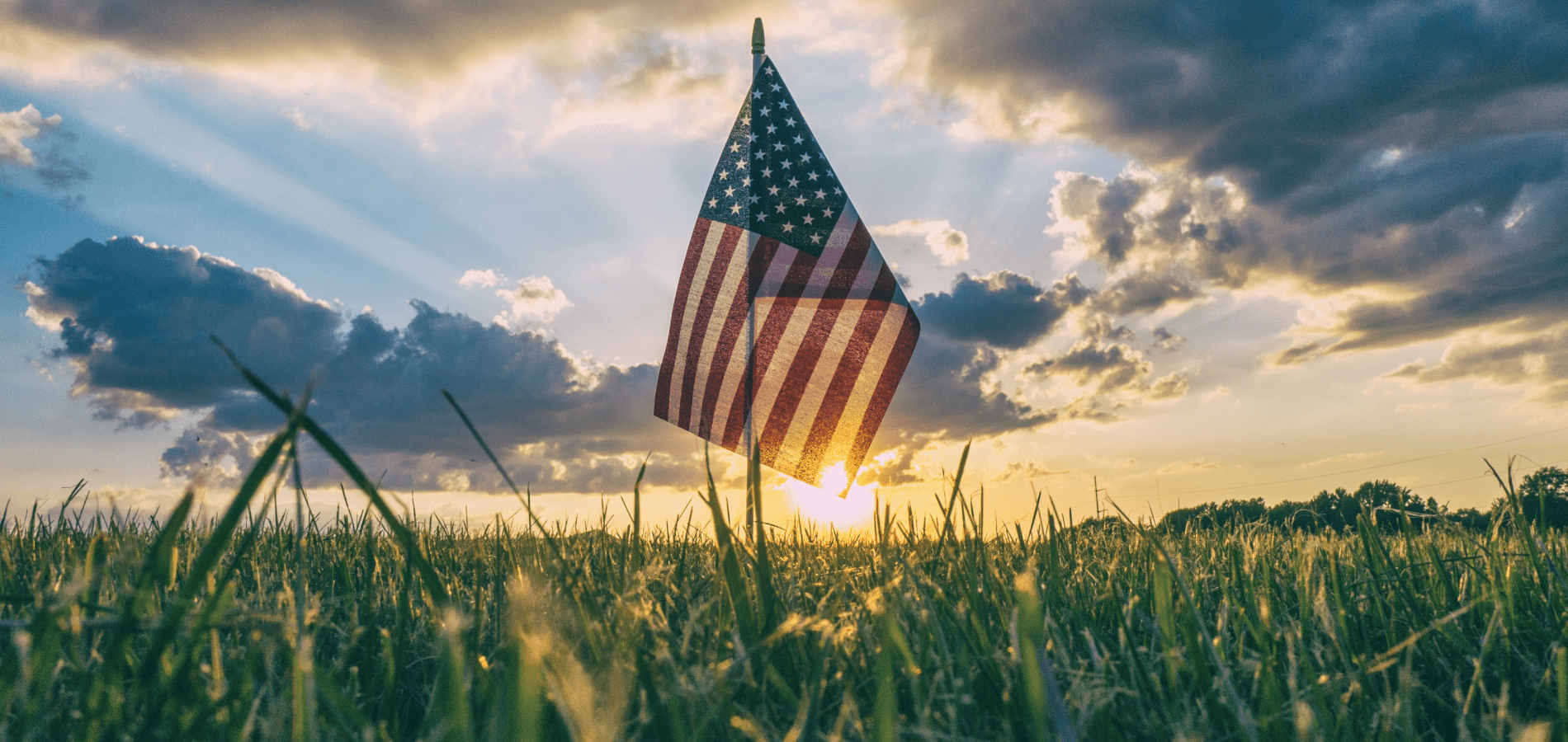 American flag in a field with a sunset