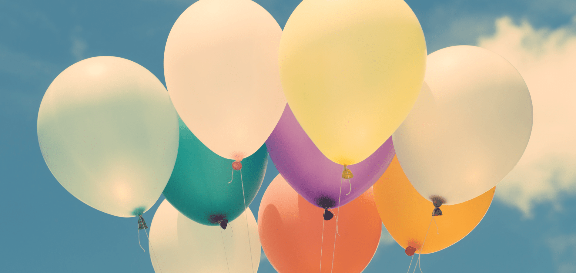 Birthday balloons against blue sky