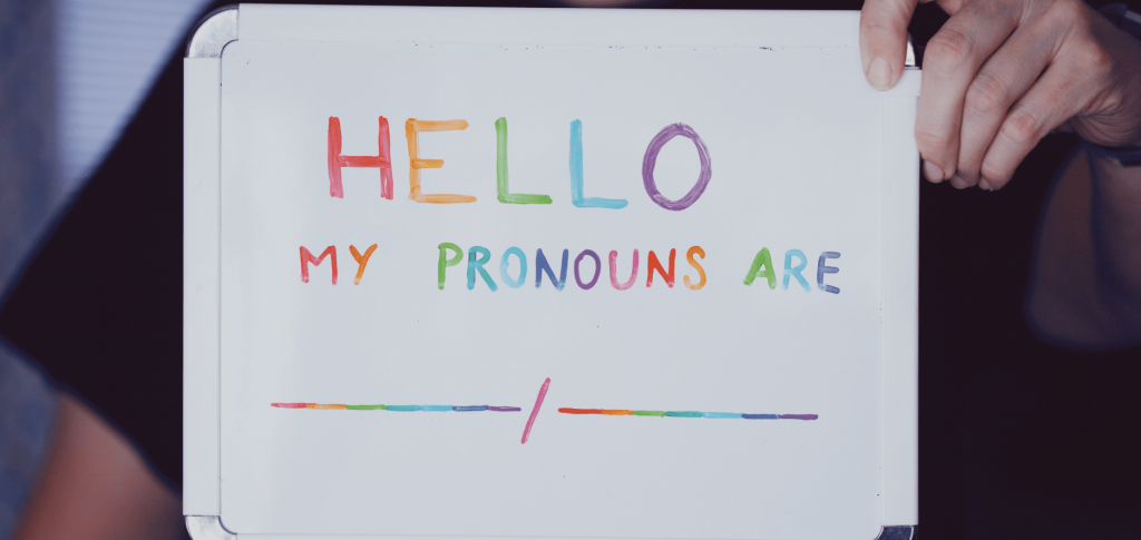 Person holding board with rainbow text