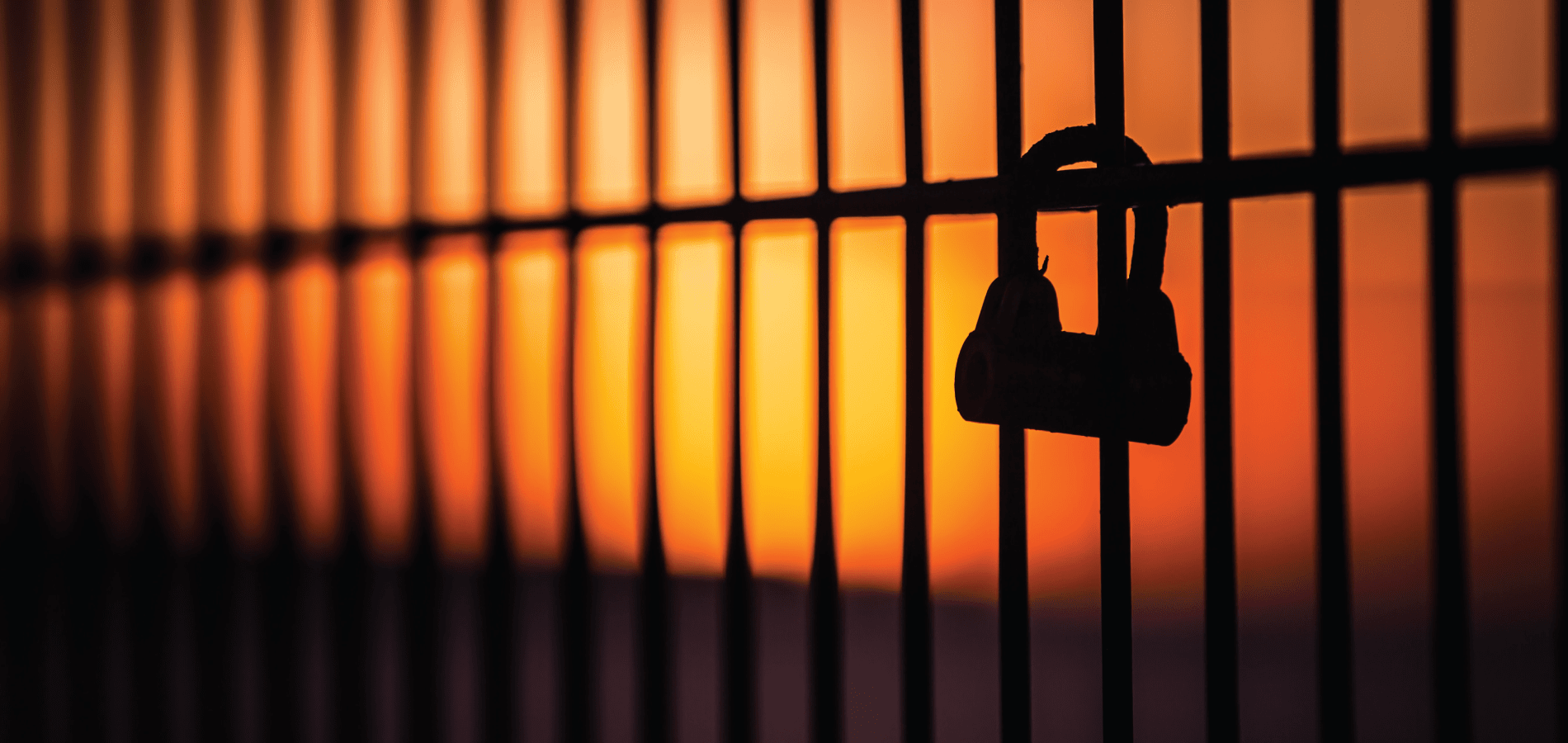 Sunset through bars with lock
