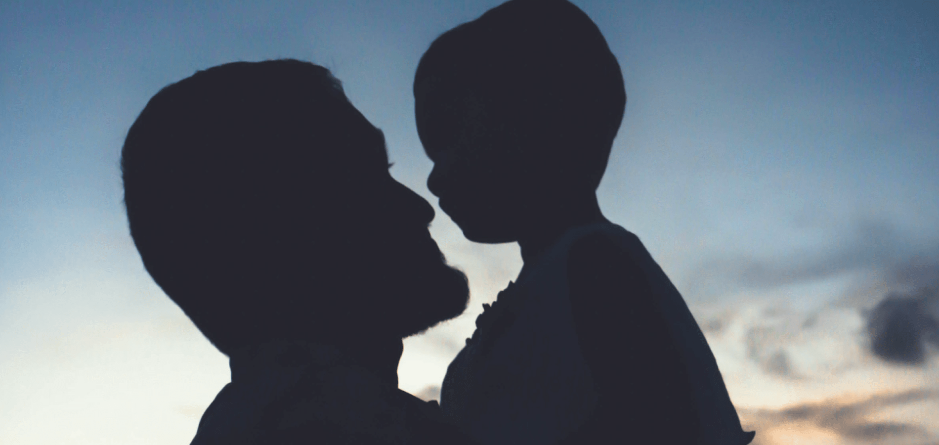 Silhouette of father holding child