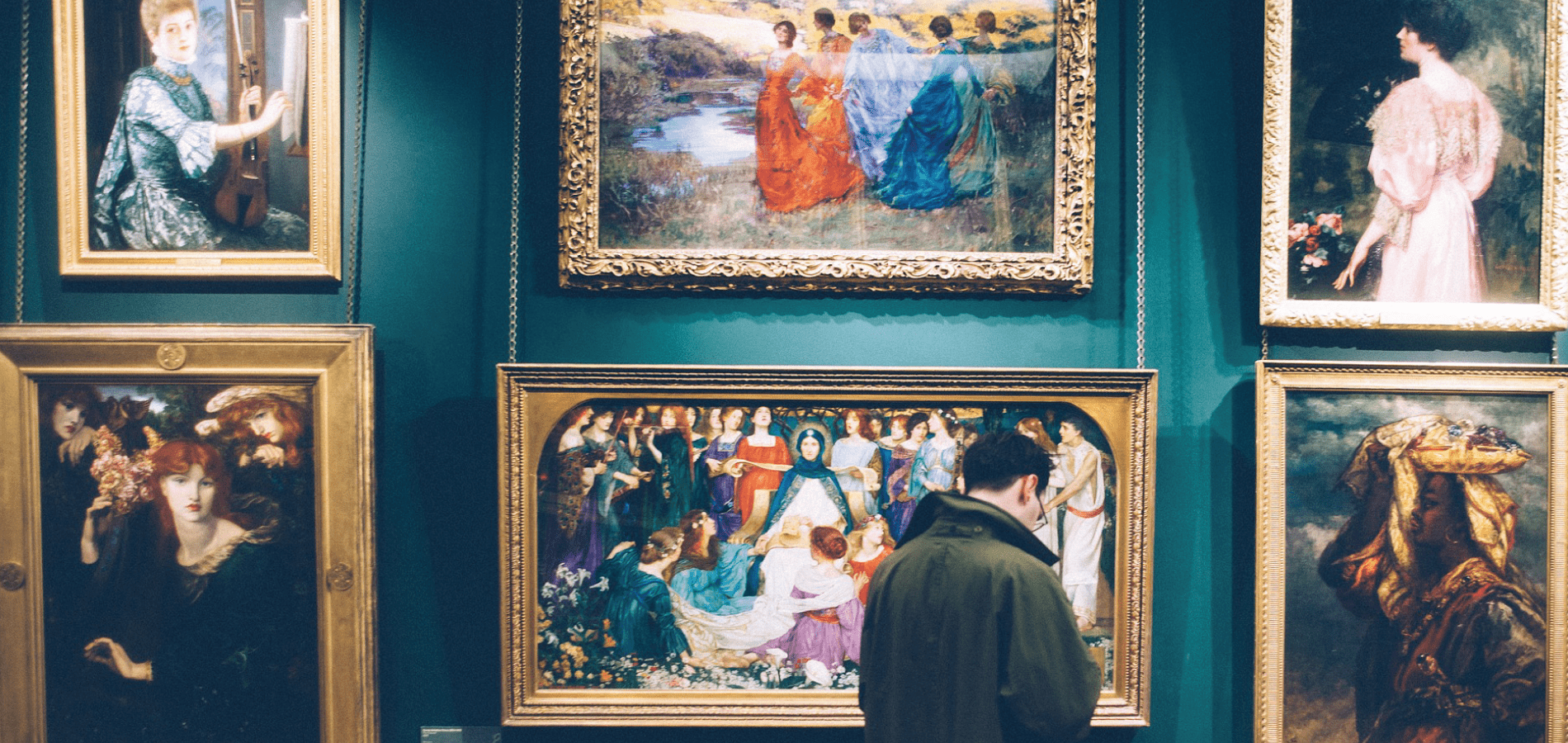 Man standing in front of paintings in a museum