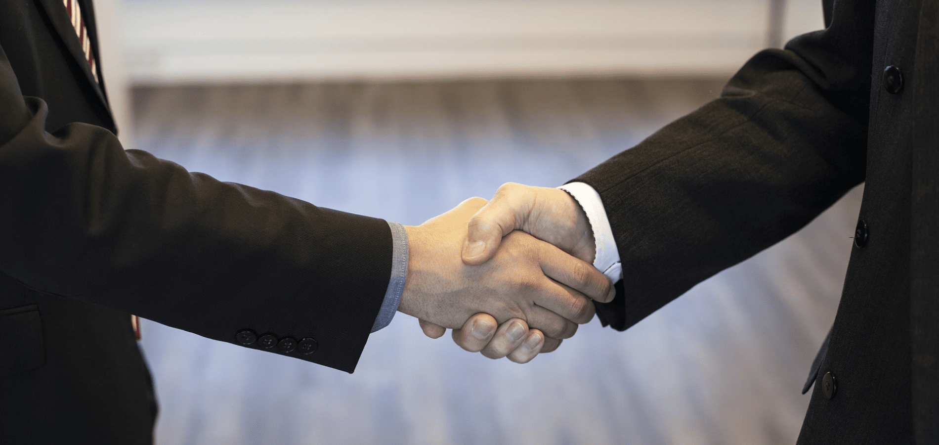 Two people in suits shaking hands