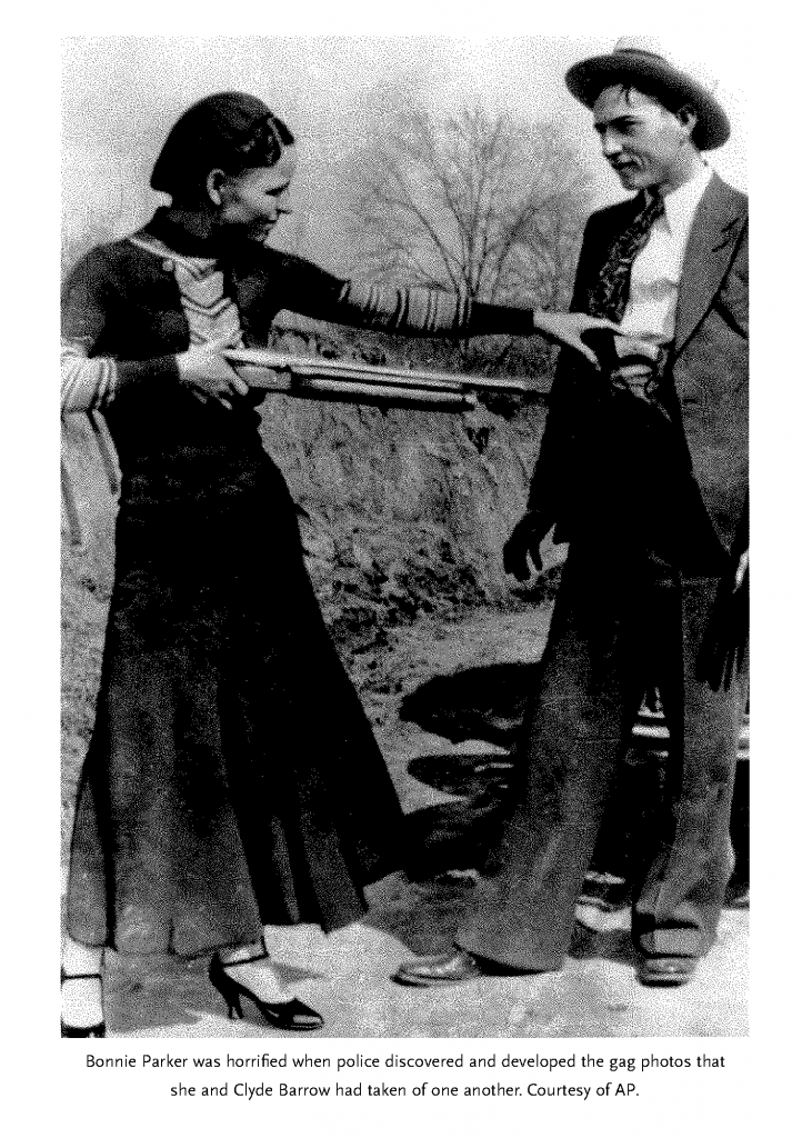 One of the staged photographs taken by Bonnie and Clyde. Bonnie, in a dark dress, points a shotgun at Clyde's belly as she takes a pistol from his waistband.