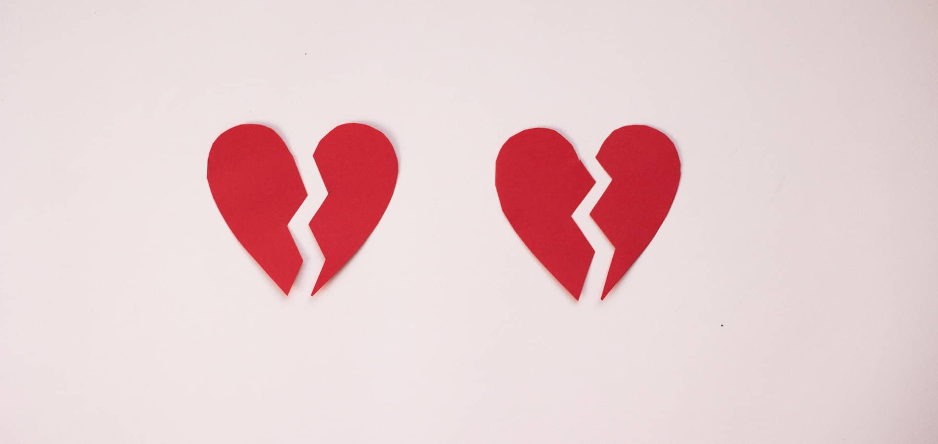 Two paper hearts, ripped in half.