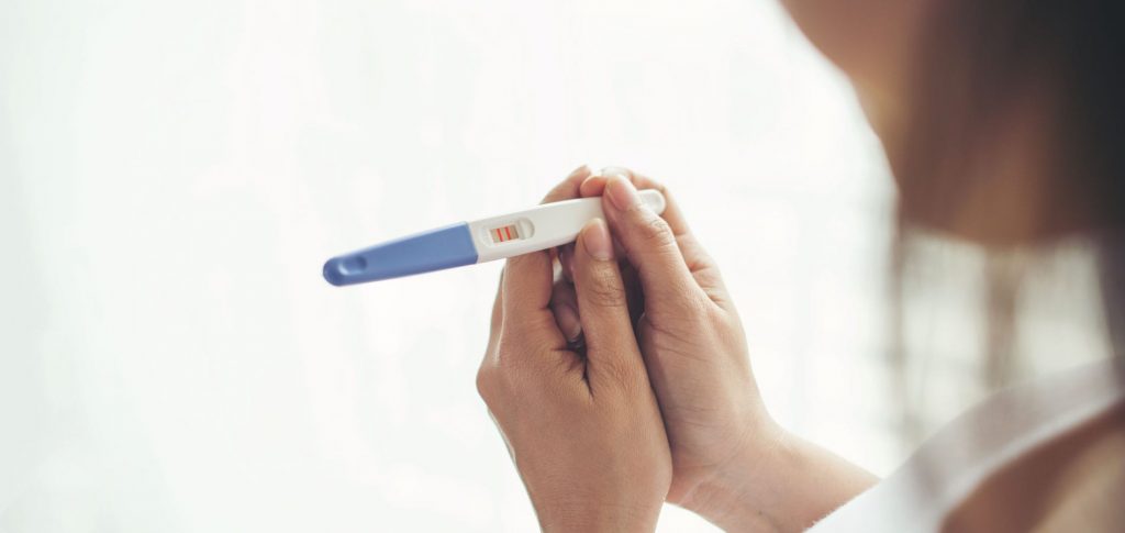 woman holding a pregnancy test