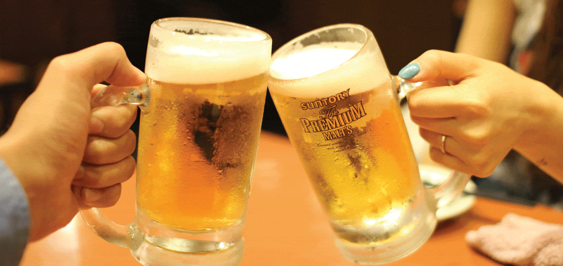 image of two people holding beer glasses during a cheers