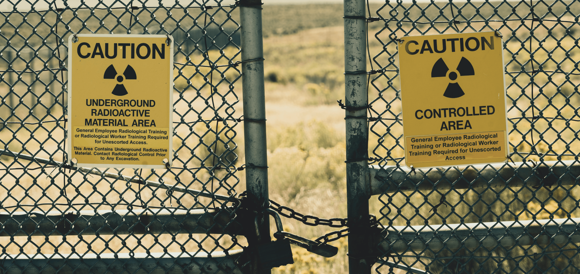 photo of radiation warning signs posted on a gate