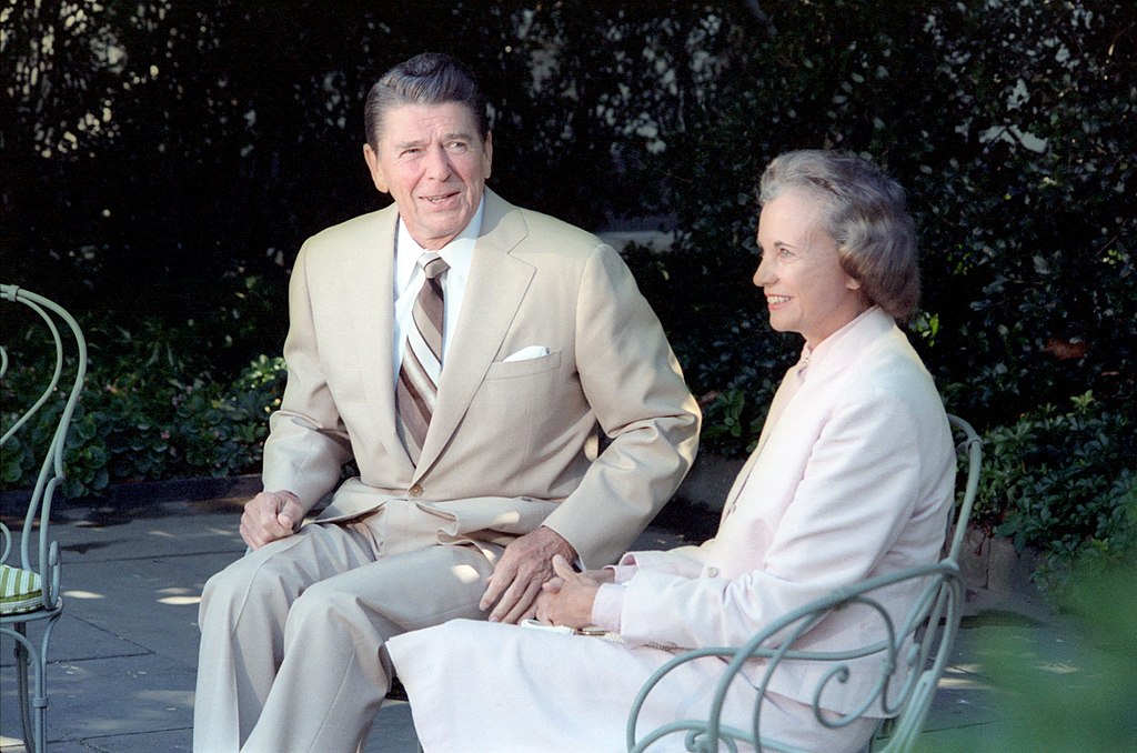 President Reagan and his Supreme Court Justice nominee Sandra Day O'Connor sitting on chairs outside at the White House