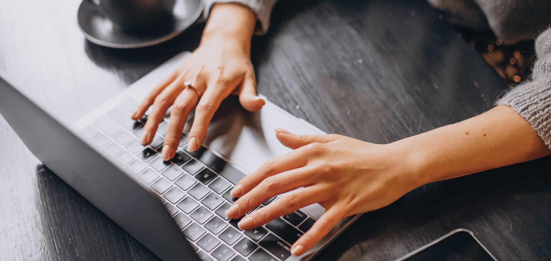 hands on a laptop on a desk