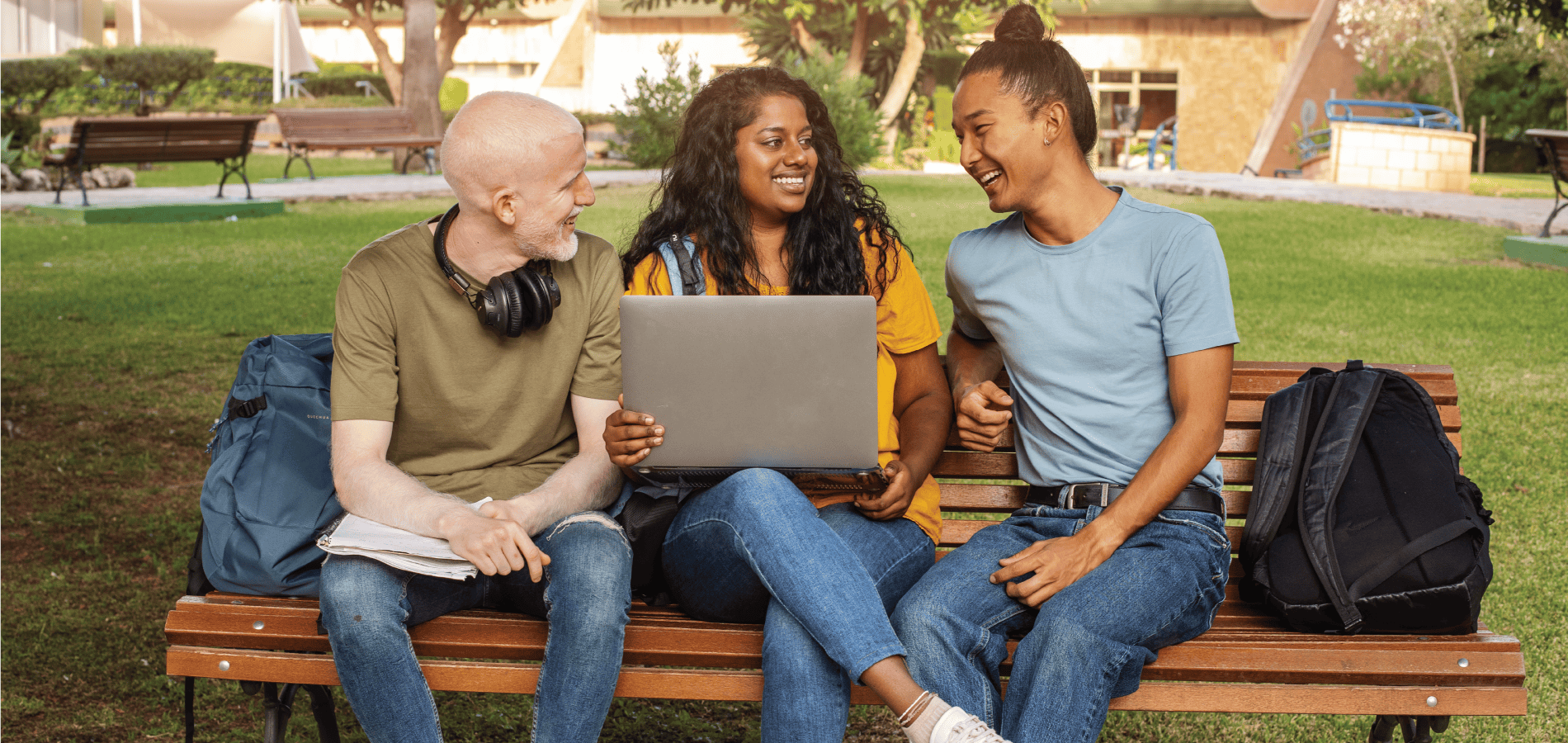 image of college students on a bench looking at a laptop