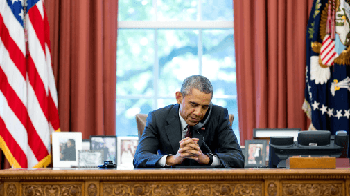 President obama on phone at desk in oval office