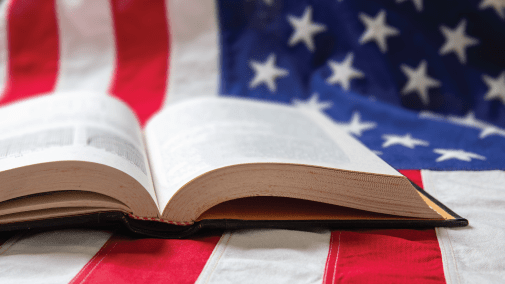 an open book laying on an American flag